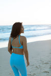 Model wearing Aura 7 Activewear Fresh Air Vita Legging Yoga Pants walking on the beach at sunset