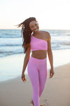 Model wearing Aura 7 Activewear Flower Capella Legging walking on the beach and smiling