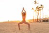 Model wearing Aura 7 Activewear Wild Vita Legging Yoga Pants doing a yoga pose on the beach at sunset